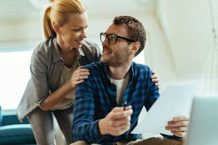 Happy couple communicating while going through home finances.